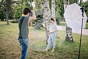 Man using photo camera for photo session of beautiful woman