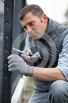Man using pliers to erect fence photo