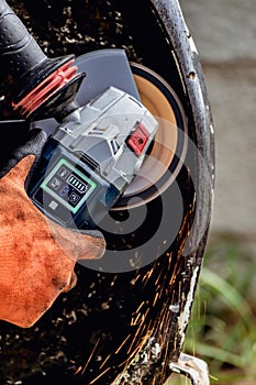 Man using portable grinder with sparkles