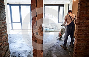 Man using power trowel machine at construction site.