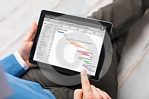Man using project management app on tablet