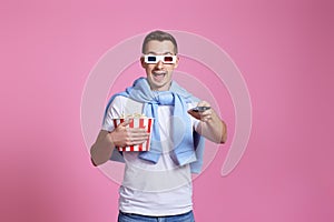 man using remote controller watching movie with big bucket of popcorns