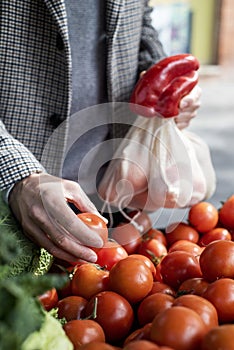 Man using reusable mesh bags at a greengrocer