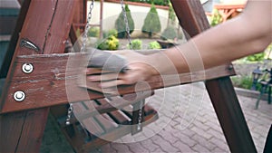 Man using sand paper on wooden bench