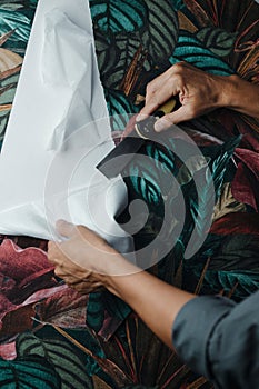 man using a scraper to remove the wallpaper photo