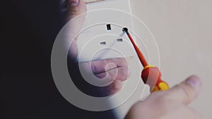 Man using screwdriver to tighten an electrical socket