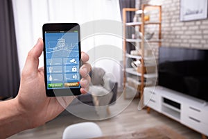 Man Using Smart Home Application On Mobile Phone