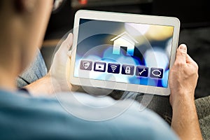 Man using smart home application in tablet to control house