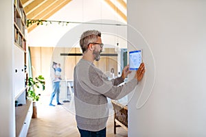 Man using smart home control panel.