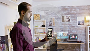Man using a smart lights application to turn on the light bulbs in the house