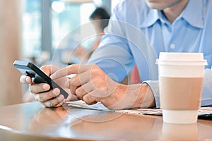 A man using smart phone in coffee shop