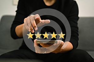 Man using smart phone and giving positive review satisfaction surveys, giving a five star rating.