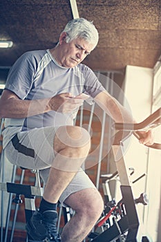 Man using smart phone in the gym. Man typing messages on