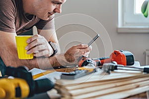 Man using smart phone and holding cup of coffee