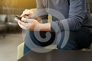 Man using smart phone on and reading message in coffee shop