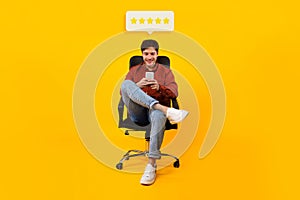 Man Using Smartphone Approving Application With Five Stars, Yellow Background