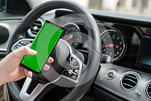 Man using smartphone on the background of a luxury class car dashboard