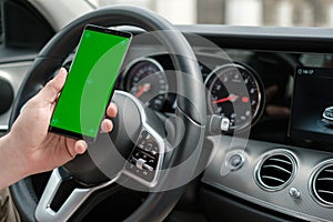 Man using smartphone on the background of a luxury class car dashboard