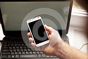 Man using smartphone, close-up, notebook on the background