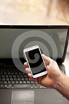 Man using smartphone, close-up, notebook on the background