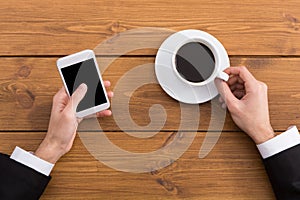 Man using smartphone in coffee shop, close-up