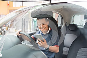 Man using smartphone while driving a car