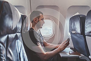 Man using a smartphone while flying in a plane.