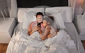 Man using smartphone while girlfriend is sleeping