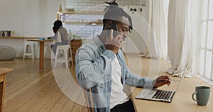 Man using smartphone and laptop at home