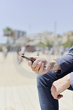 Man using a smartphone next to the beach