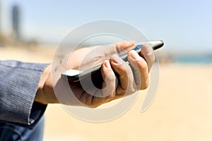 Man using a smartphone next to the beach