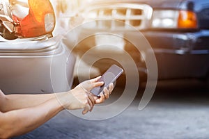 Man using smartphone at roadside after traffic accident