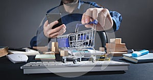 Man using smartphone and showing shopping cart. Online shopping