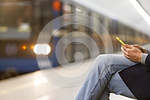 Man using smartphone subway, underground station, train on blurred background