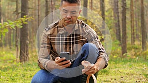 Man using smartphone to identify mushroom