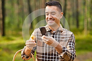 man using smartphone to identify mushroom