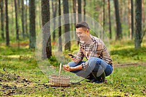 man using smartphone to identify mushroom