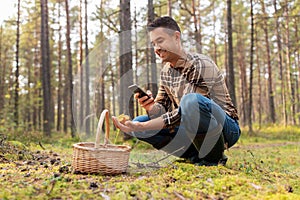 man using smartphone to identify mushroom