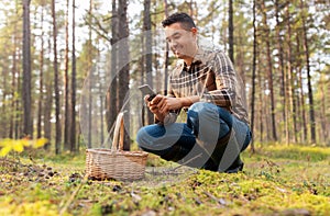 man using smartphone to identify mushroom