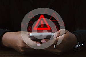 Man using smartphone with warning sign.Notification error and virus detection spyware, Internet network security concept.Computer