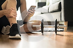 Man using smartphone during workout at home