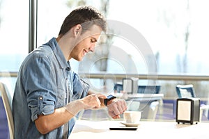 Man using a smartwatch in a coffee shop
