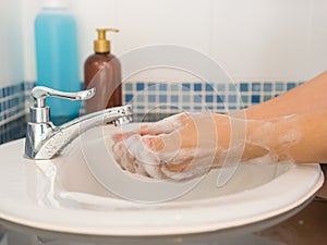 Man using soap to washing hands in the bathroom