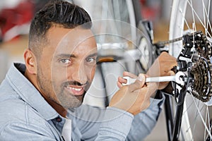 Man using spanner to work on bicycle wheel