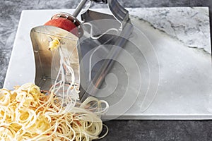 Man using spiralizer to cut apple into strips.