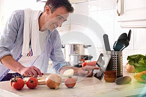 Man using a tablet to prepare a dish