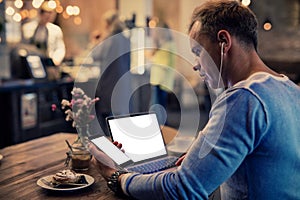 Man using tech gadgets in cafe photo