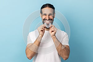 Man using teeth whitening braces, dental aligner retainer, dental clinic for beautiful teeth.