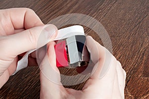 Man using teflon tape to seal water ball faucet with red valve. Wrap PTFE tape on valve thread. Brass water tap close up