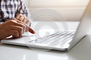 Man using touchpad on notebook with his finger